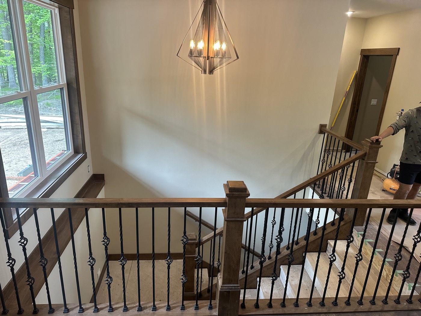 Interior stairway with a stained wood handrail and wrought-iron balusters