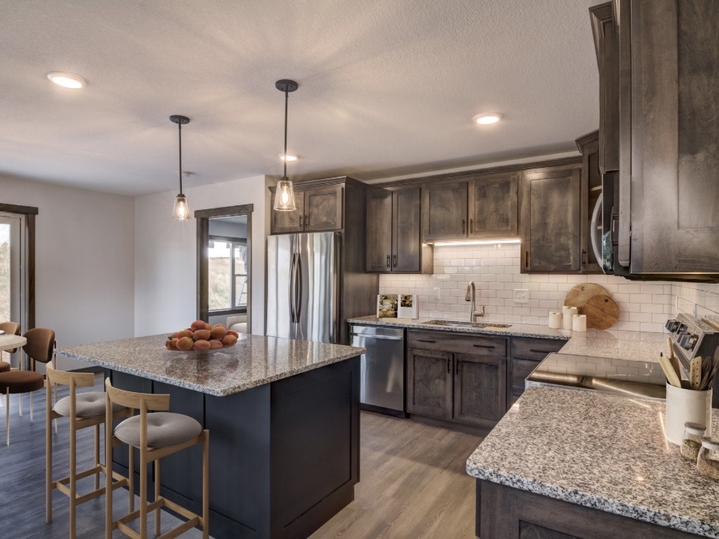 Finished kitchen with stained cabinetry, granite counters and a tile backsplash